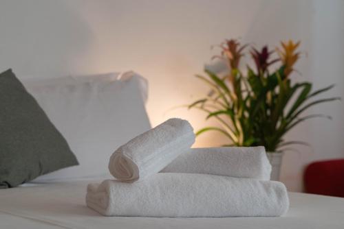 a stack of towels sitting on a bed at Bed & Bike Ferrara in Ferrara