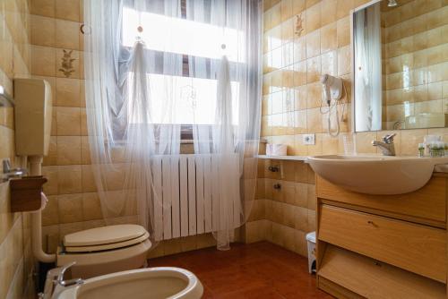 フェラーラにあるBed & Bike Ferraraのバスルーム(トイレ、洗面台付)、窓が備わります。