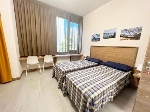 une chambre d'hôtel avec deux lits et deux chaises dans l'établissement Sissi Comfort Rooms Foresteria Lombarda, à Monza