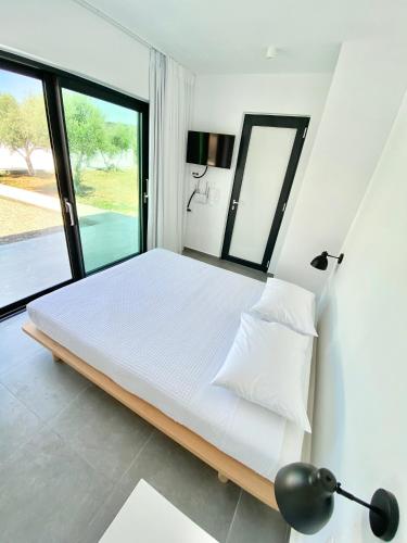 a bedroom with a large bed with a large window at Lefko Apartments in Tavronitis