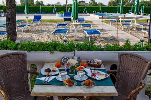 a table with plates of food on it with chairs at Hotel Villa Sara in Mestre