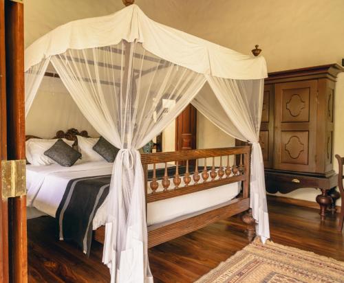 a bedroom with a canopy bed with curtains at Heenatigala Walawwa in Talpe