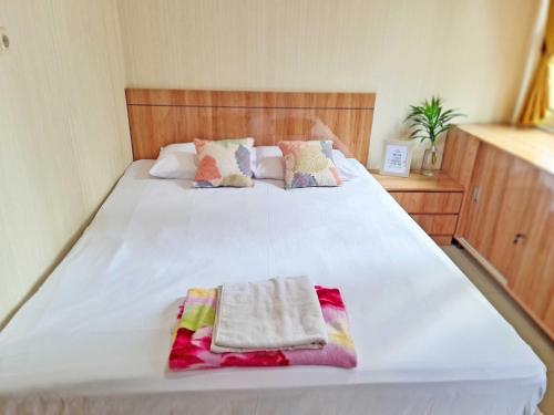 uma grande cama branca com duas toalhas em 37 Guesthouse em Jakarta
