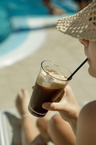 a woman holding a drink in a glass at Frank Apartments in Amoudara Herakliou