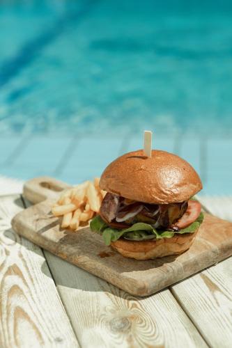 a hamburger and french fries on a cutting board at Frank Apartments in Amoudara Herakliou