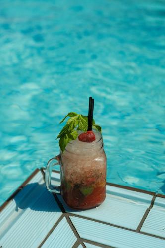 a drink in a glass jar next to a swimming pool at Frank Apartments in Amoudara Herakliou