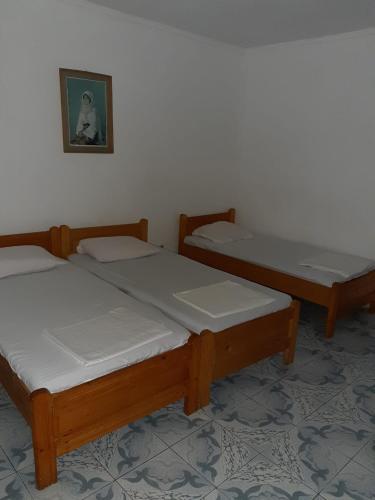 2 Einzelbetten in einem Zimmer mit einem Bild an der Wand in der Unterkunft Vila Margaritar in Eforie Sud
