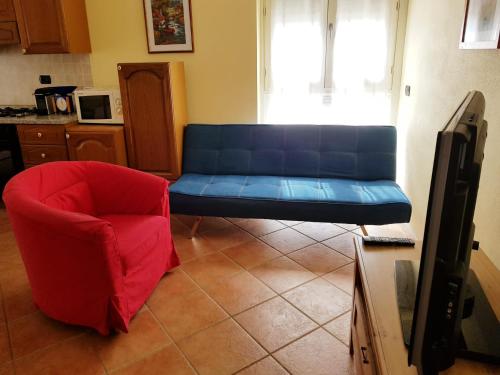 a living room with a blue couch and a red chair at Langhe e Roero - Casa da Angela in Sommariva Perno