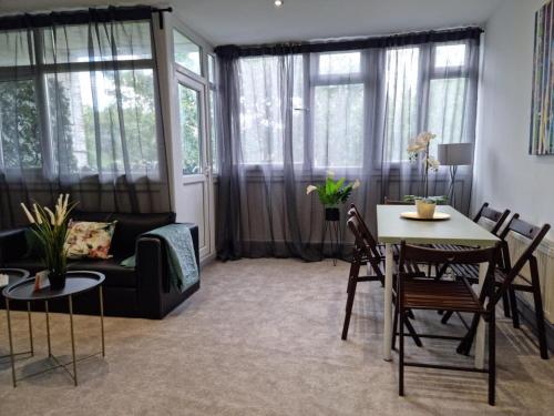 uma sala de estar com um sofá, uma mesa e cadeiras em Remarkable 3-Bed Apartment in London em Londres