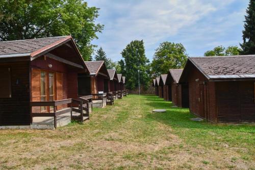 a row of wooden cabins in a row at Autokemp Žlutice in Žlutice