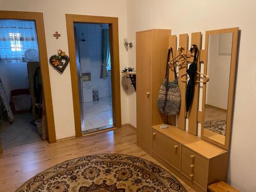a living room with a dresser and a mirror at Schöne Ferienwohnung in Bahnhofsnähe für Urlaub, Studium oder Arbeit in Deggendorf