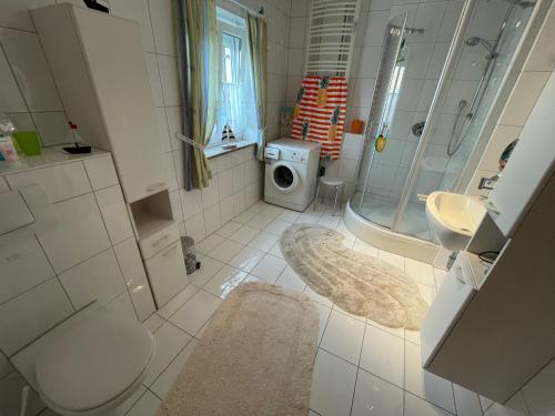 a bathroom with a shower sink and a washing machine at Schöne Ferienwohnung in Bahnhofsnähe für Urlaub, Studium oder Arbeit in Deggendorf