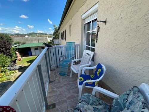 a balcony with two chairs and a table at Schöne Ferienwohnung in Bahnhofsnähe für Urlaub, Studium oder Arbeit in Deggendorf
