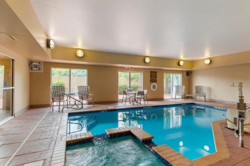 a swimming pool with a table and chairs in a building at Comfort Inn in Huntsville