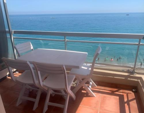 a table and chairs on a balcony with a view of the ocean at Studio Cabine Sète Corniche Vue Mer 1ère ligne in Sète
