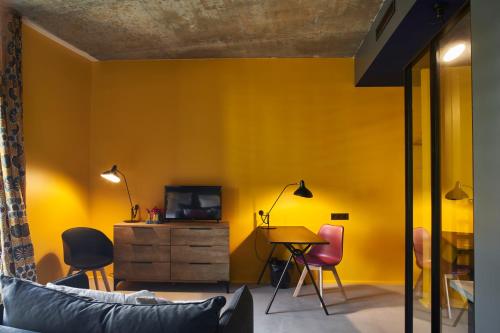 salon z żółtymi ścianami, stołem i krzesłami w obiekcie Hotel La Zoologie & Spa Bordeaux w mieście Bordeaux