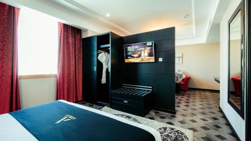 a hotel room with a bed and a tv at Arman Hotel Juffair Mall in Manama