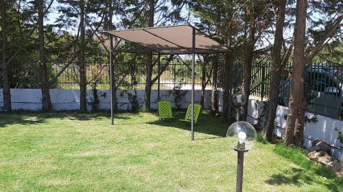 un padiglione in un cortile con due sedie verdi di VILLA LEYLAND a Laureana Cilento