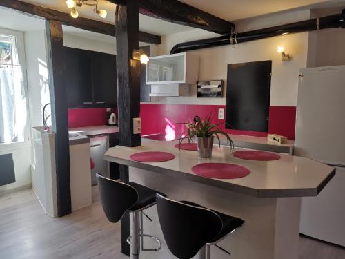 uma cozinha com uma ilha com cadeiras e um frigorífico em Superbe maison de village em Sourribes
