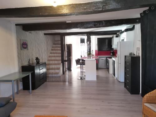 eine Küche und ein Wohnzimmer mit einem Tisch und einem Kühlschrank in der Unterkunft Superbe maison de village in Sourribes