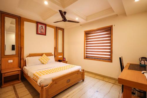 a bedroom with a bed and a desk and a window at Hotel Maru Casa in Jaipur