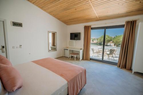 a bedroom with a bed and a view of a patio at Ali Baba Ciftligi Boutique Hotel in Alaçatı