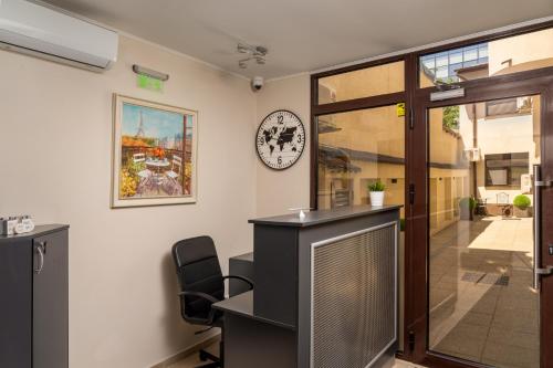 an office with a desk and a clock on the wall at Casa 86 in Bucharest