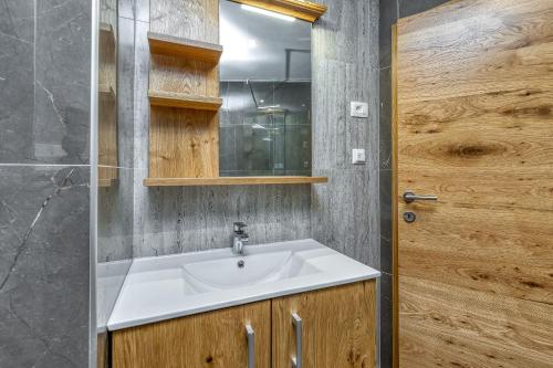 a bathroom with a sink and a wooden door at Casa Viktor in Umag