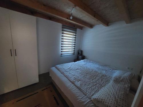 een kleine slaapkamer met een bed en een raam bij Village House Gradac in Šavnik