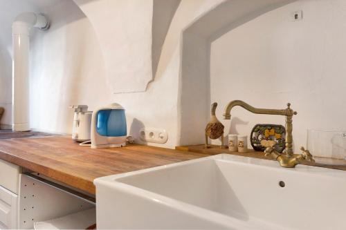 una cucina con lavandino bianco e bancone in legno di Huber Stube a Laion