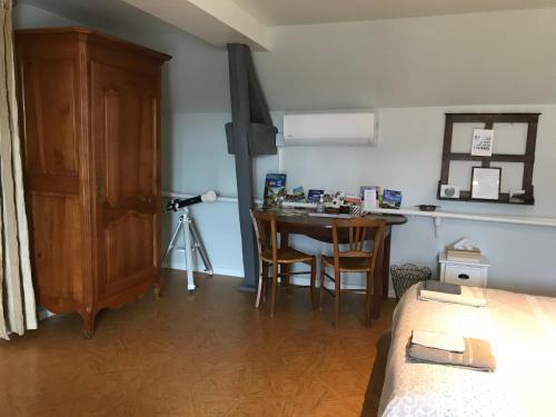 um quarto com uma cama e uma mesa com uma câmara em Le puits de la Montrée em Chahaignes
