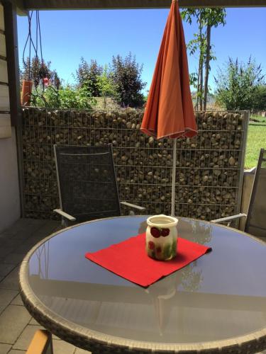 a table with a red napkin and an orange umbrella at Ferienwohnungen "Blumenwiese" in Dillingen an der Donau