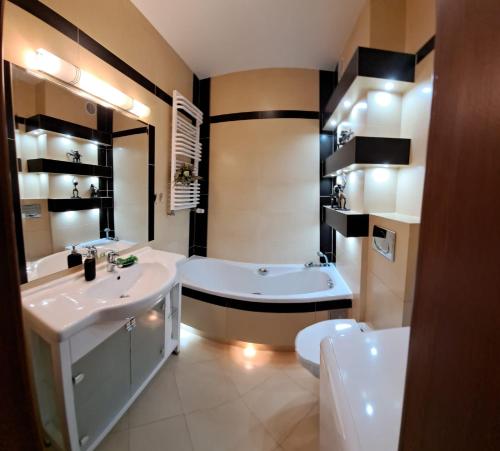 a bathroom with a tub and a sink and a bath tub at Apartament 15 min od morza in Gdańsk