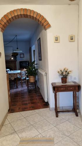 un pasillo con un arco en una casa con una mesa en monte penna, en Cardoso