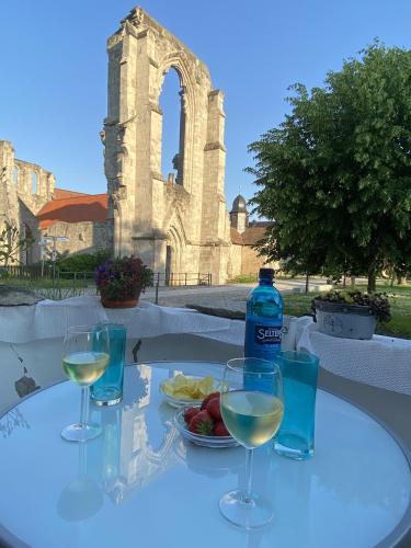 a table with three glasses of white wine and a bottle at Klosterhotel Walkenried in Walkenried