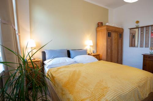 a bedroom with a bed with two pillows and a plant at Klosterhotel Walkenried in Walkenried