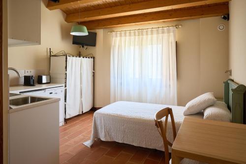 cocina y dormitorio con cama y lavamanos en Los Apartamentos del Palacio en Casalarreina