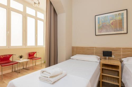 1 dormitorio con 2 camas y 2 sillas rojas en ApartEasy - Family 4-Bedroom Apartment en Barcelona