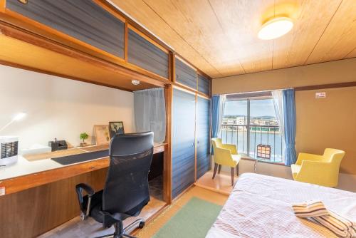 小田原市にある汐の香 - shio no kaoriのベッド、デスク、椅子が備わる客室です。