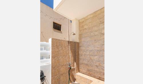 a bathroom with a shower with a stone wall at Mediterranean dream in Voroklini