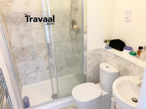 a bathroom with a shower and a toilet and a sink at Travaal.©om - 2 Bed Serviced Apartment Farnborough in Farnborough