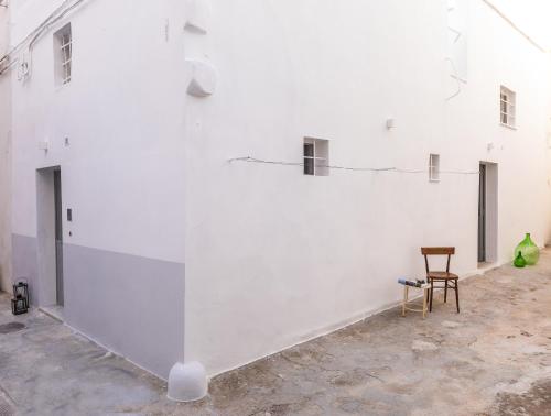 a chair sitting next to a white wall at Casa Marta holiday home in Tricase
