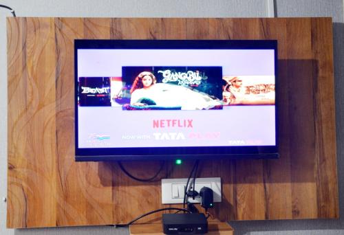 a flat screen tv hanging on a wooden wall at The Candy Heights in Rānchī