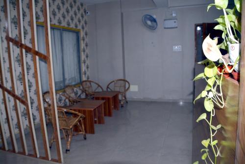 une chambre avec des tables et des chaises et une horloge sur le mur dans l'établissement The Candy Heights, à Rānchī