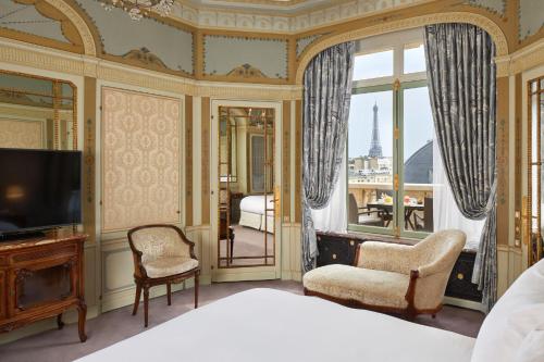 um quarto com uma cama, uma televisão e uma varanda em Hôtel Raphael em Paris