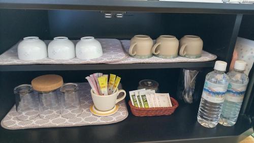 a shelf with bottles of water and other items at Guest House Yamada in Date