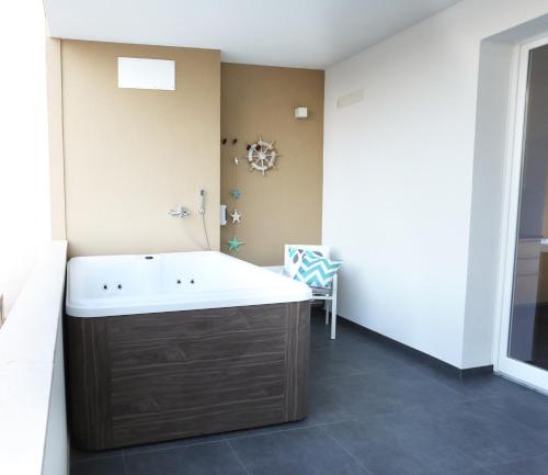 a bathroom with a large tub in a room at Dimora Mothia in Marsala