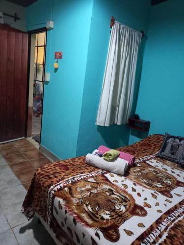 two beds in a room with a blue wall at La casita de abu! in Salta