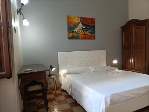 a bedroom with a bed and a table and a painting at Ortigia Basic -Locazione Turistica in Syracuse