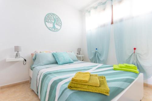 een slaapkamer met een bed met gele handdoeken erop bij IRIS Holiday House Fuerteventura in Costa de Antigua